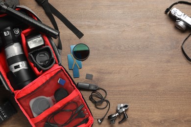 Photo of Photographer's equipment on wooden background, flat lay. Space for text