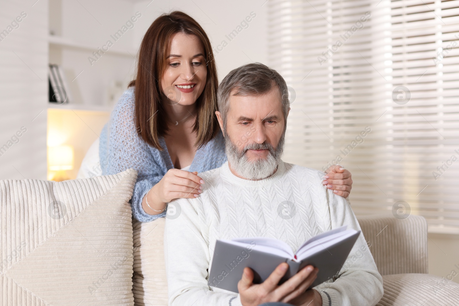 Photo of Happy adult daughter and her father spending time together at home