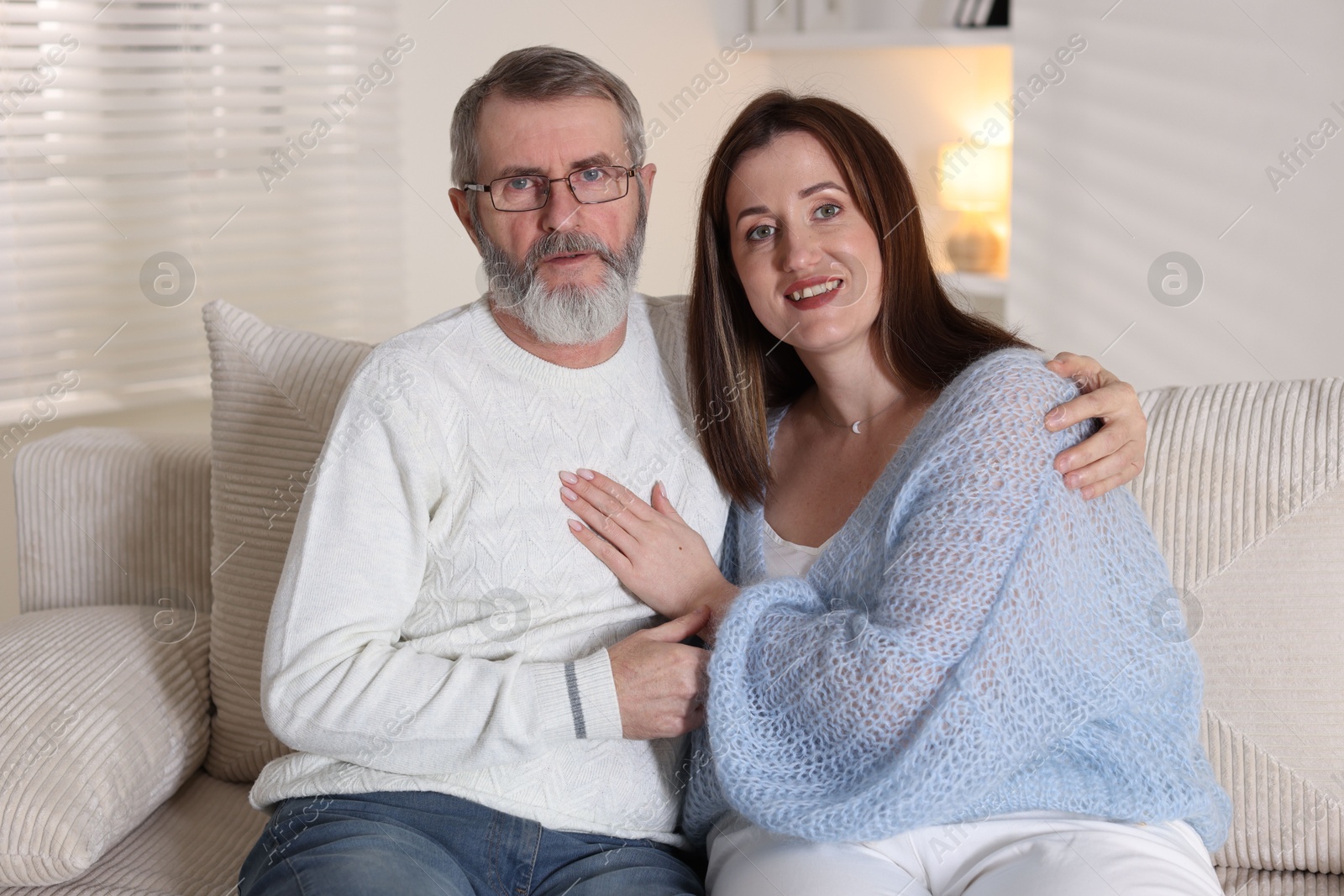 Photo of Family portrait of happy daughter and her father on sofa at home