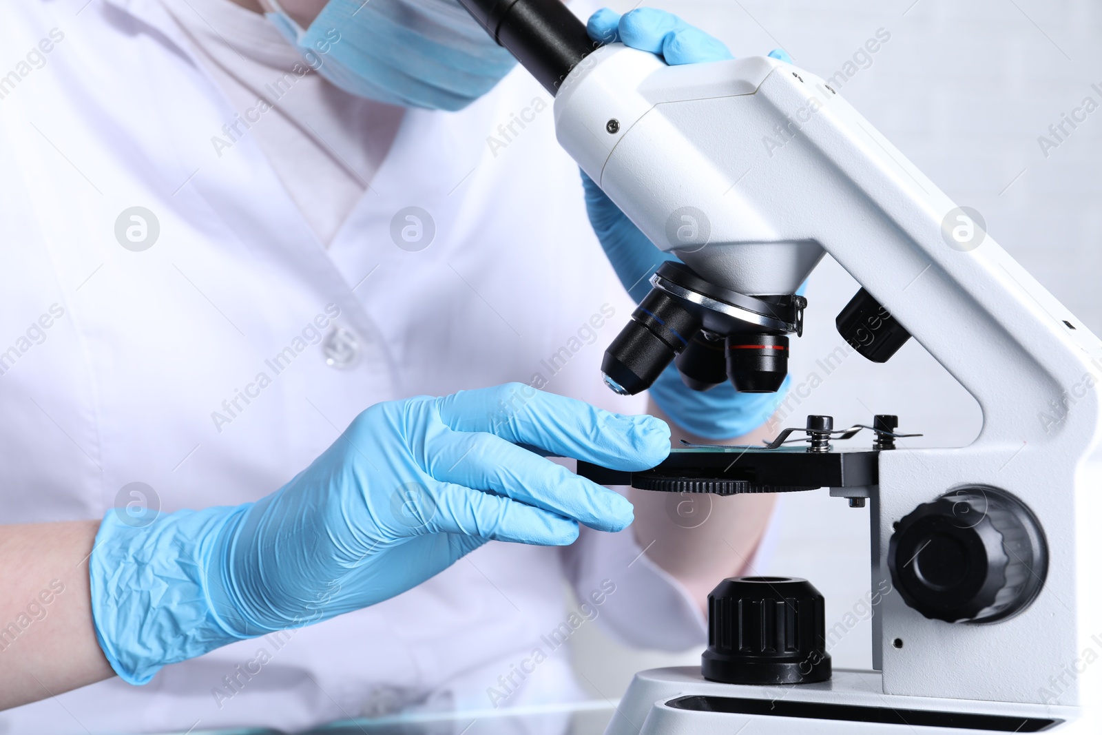 Photo of Laboratory testing. Scientist examining sample under microscope indoors, closeup