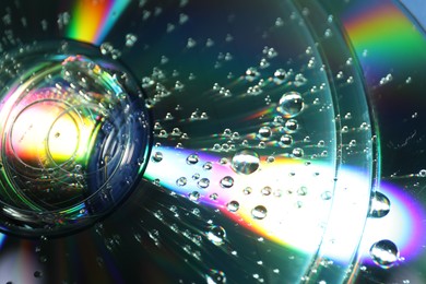 Photo of Compact discs with drops as background, closeup