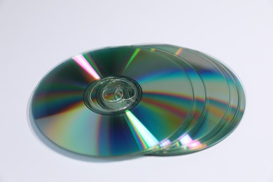 Photo of Many shiny compact discs on light background