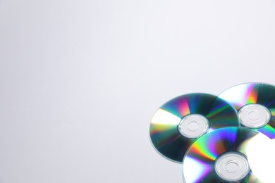 Photo of Many shiny compact discs on light background. Space for text