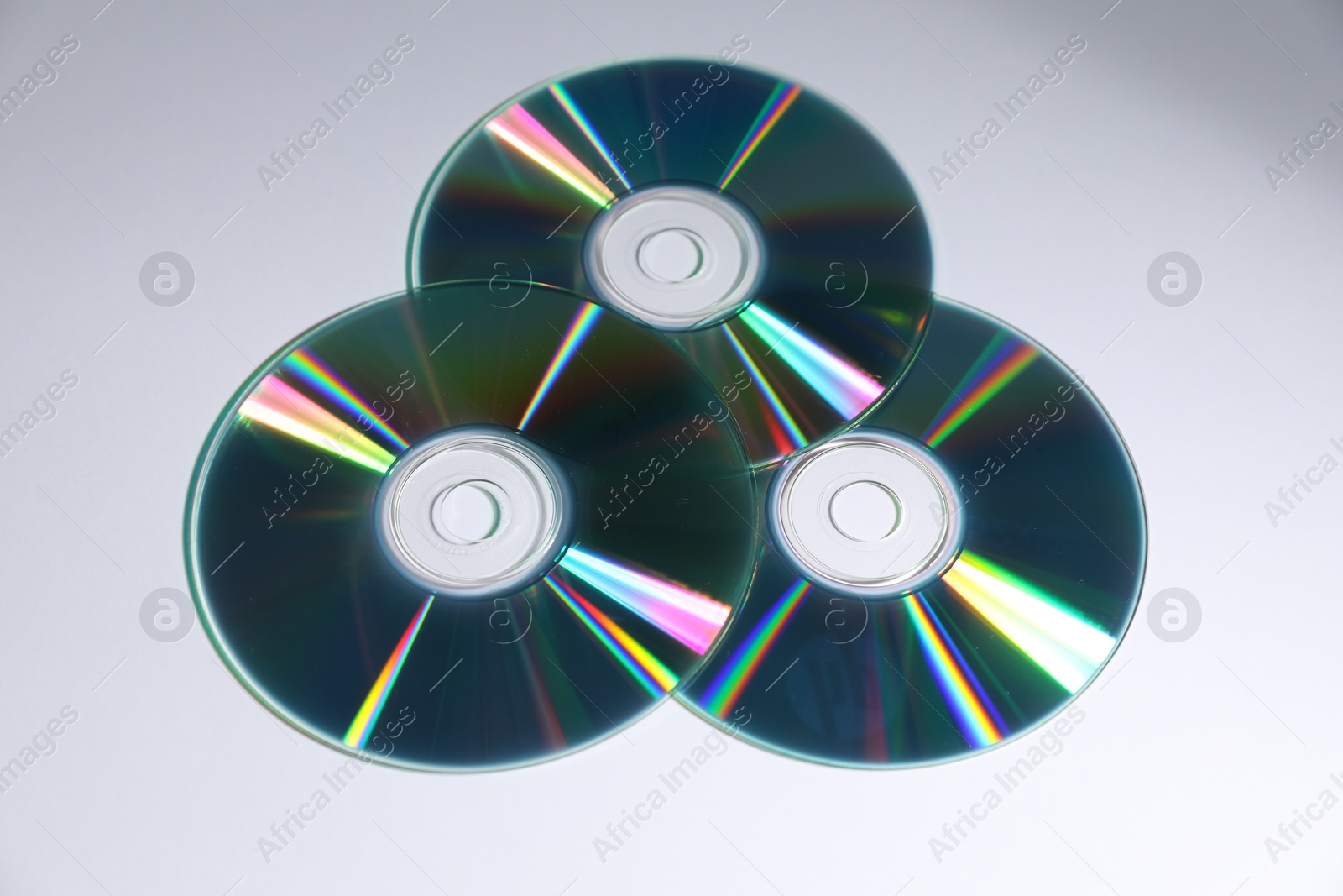 Photo of Many shiny compact discs on light background