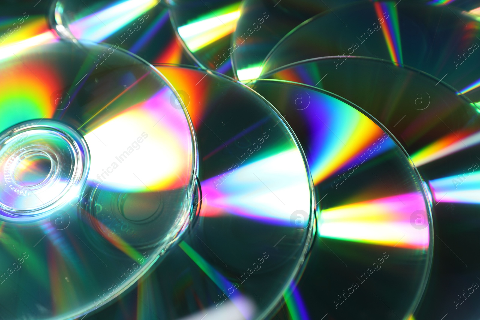 Photo of Many shiny compact discs as background, closeup