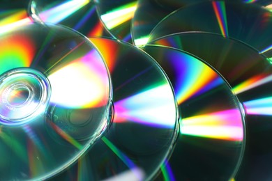 Photo of Many shiny compact discs as background, closeup