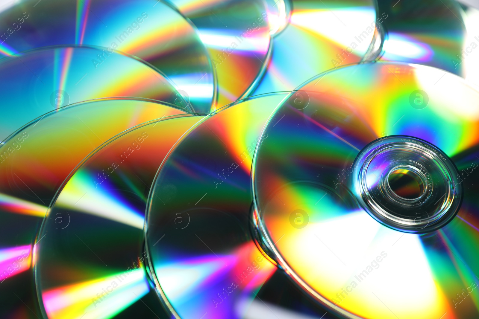 Photo of Many shiny compact discs as background, closeup