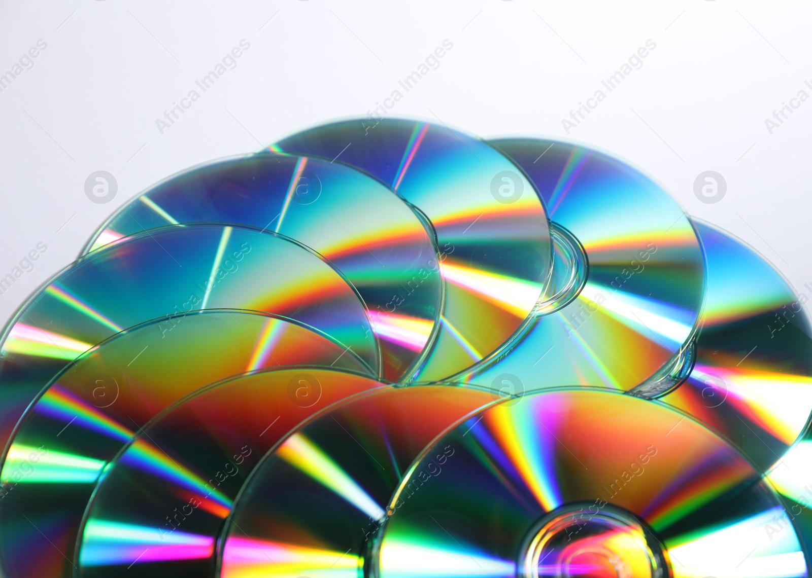 Photo of Many shiny compact discs on light background