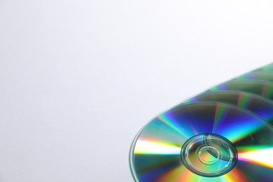 Photo of Many shiny compact discs on light background. Space for text