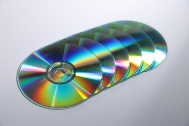 Photo of Many shiny compact discs on light background