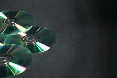 Photo of Shiny compact discs on black background. Space for text