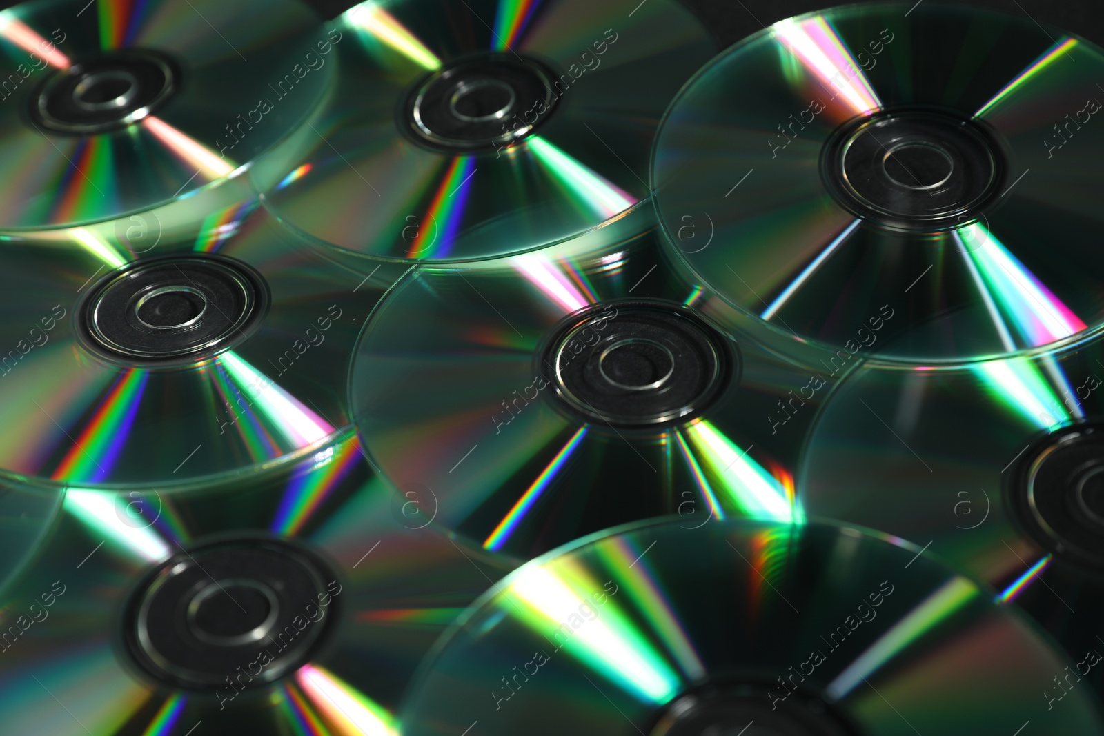 Photo of Many shiny compact discs as background, closeup