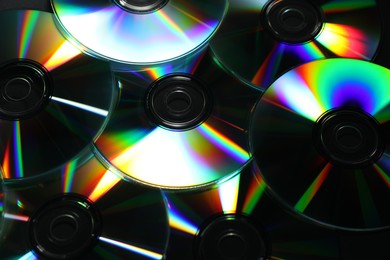 Photo of Many shiny compact discs as background, closeup