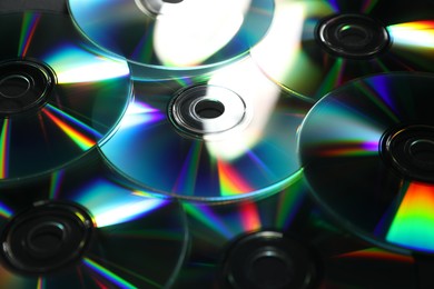 Photo of Many shiny compact discs as background, closeup