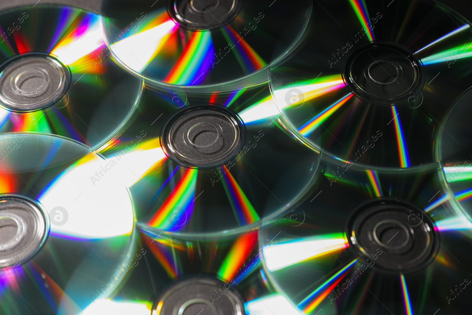 Photo of Many shiny compact discs as background, closeup