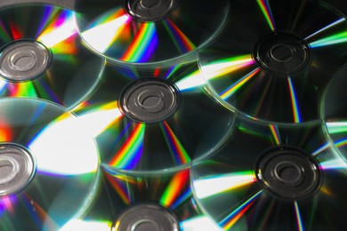 Photo of Many shiny compact discs as background, closeup