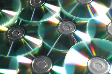 Photo of Many shiny compact discs as background, closeup