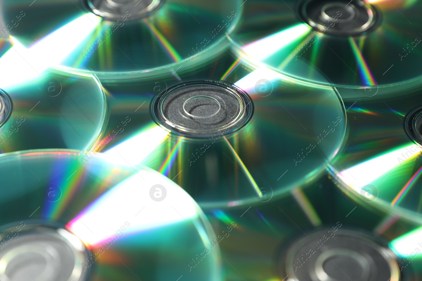 Photo of Many shiny compact discs as background, closeup