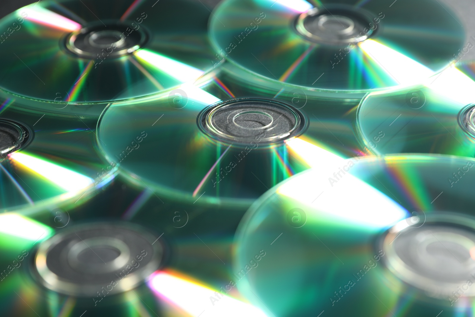 Photo of Many shiny compact discs as background, closeup