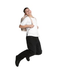 Teenage boy with backpack jumping on white background