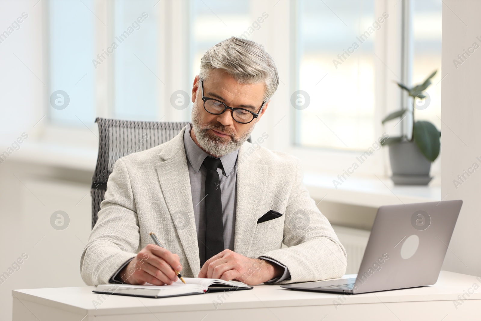 Photo of Banker taking notes at desk in office