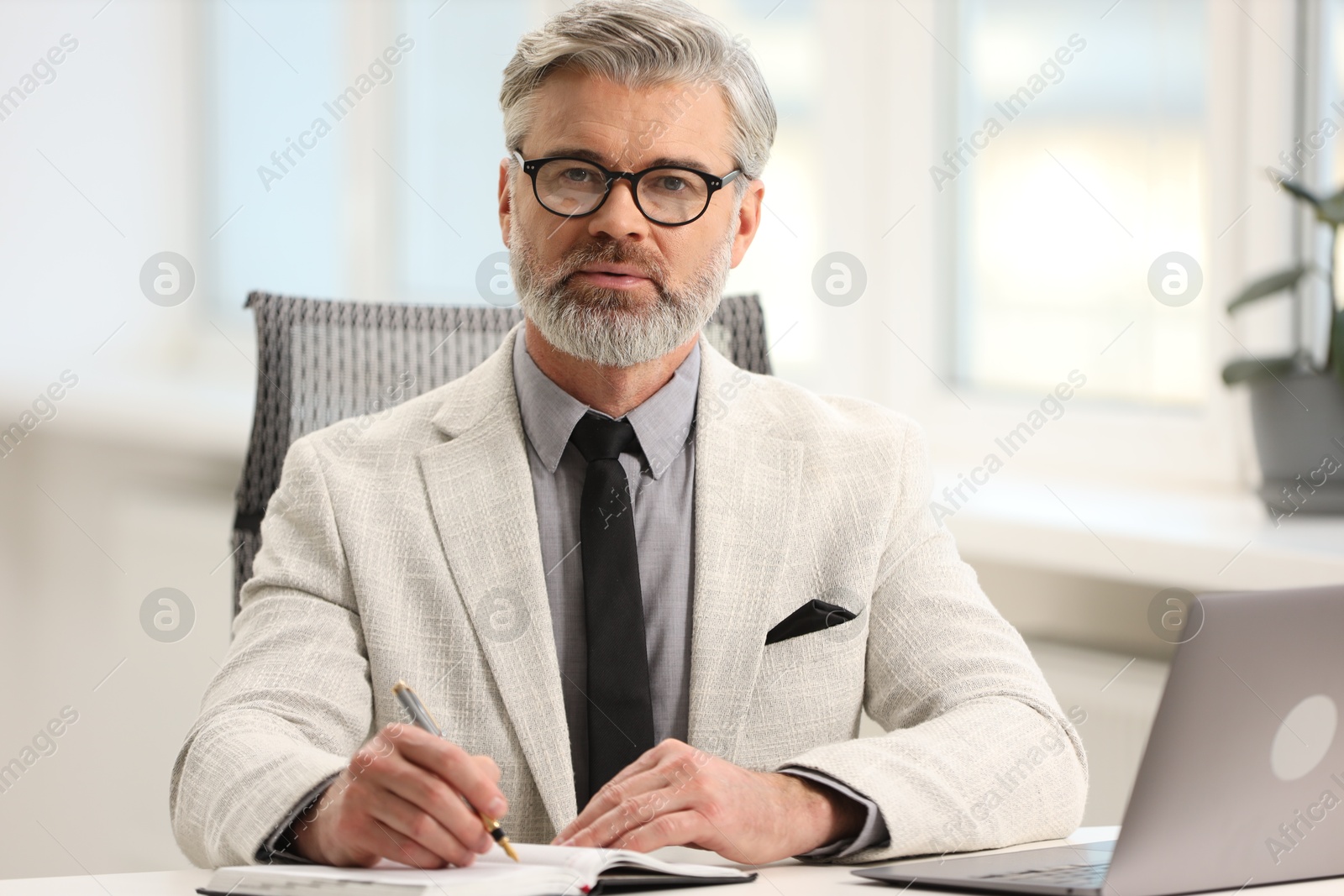 Photo of Banker taking notes at desk in office