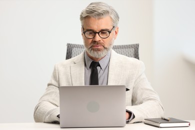 Photo of Banker working on laptop at desk in office