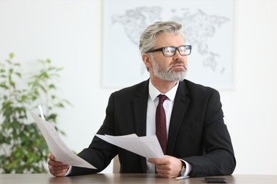 Photo of Portrait of banker with documents at desk in office