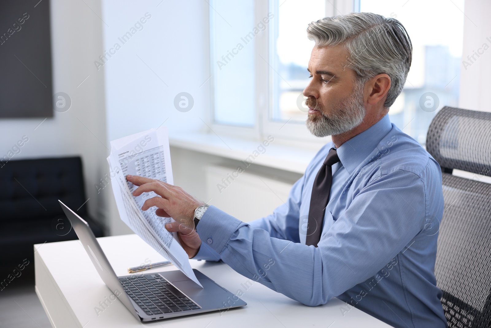 Photo of Banker with documents at desk in office