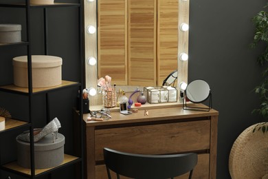 Photo of Makeup room. Mirrors, different beauty products, shoes, dresser and chair indoors