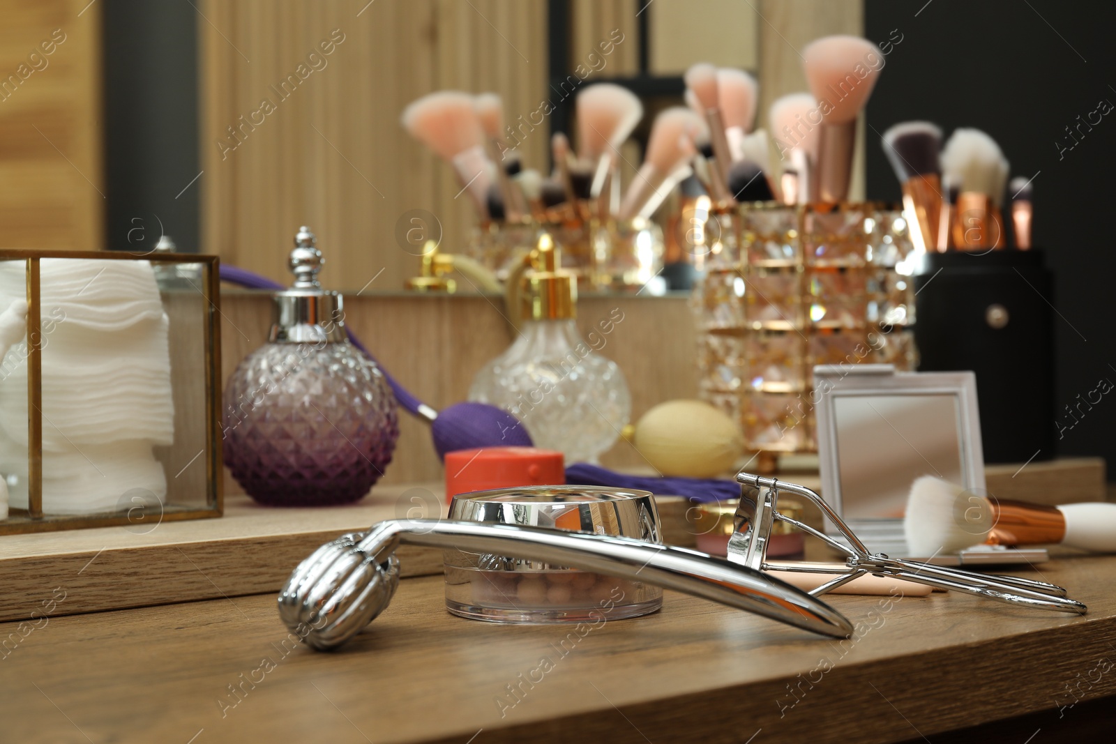 Photo of Makeup room. Different beauty products on wooden dressing table indoors, closeup