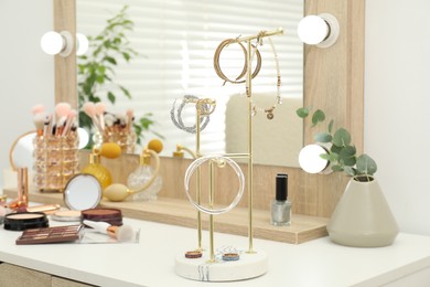 Photo of Makeup room. Dressing table with mirror, jewelry and different beauty products indoors