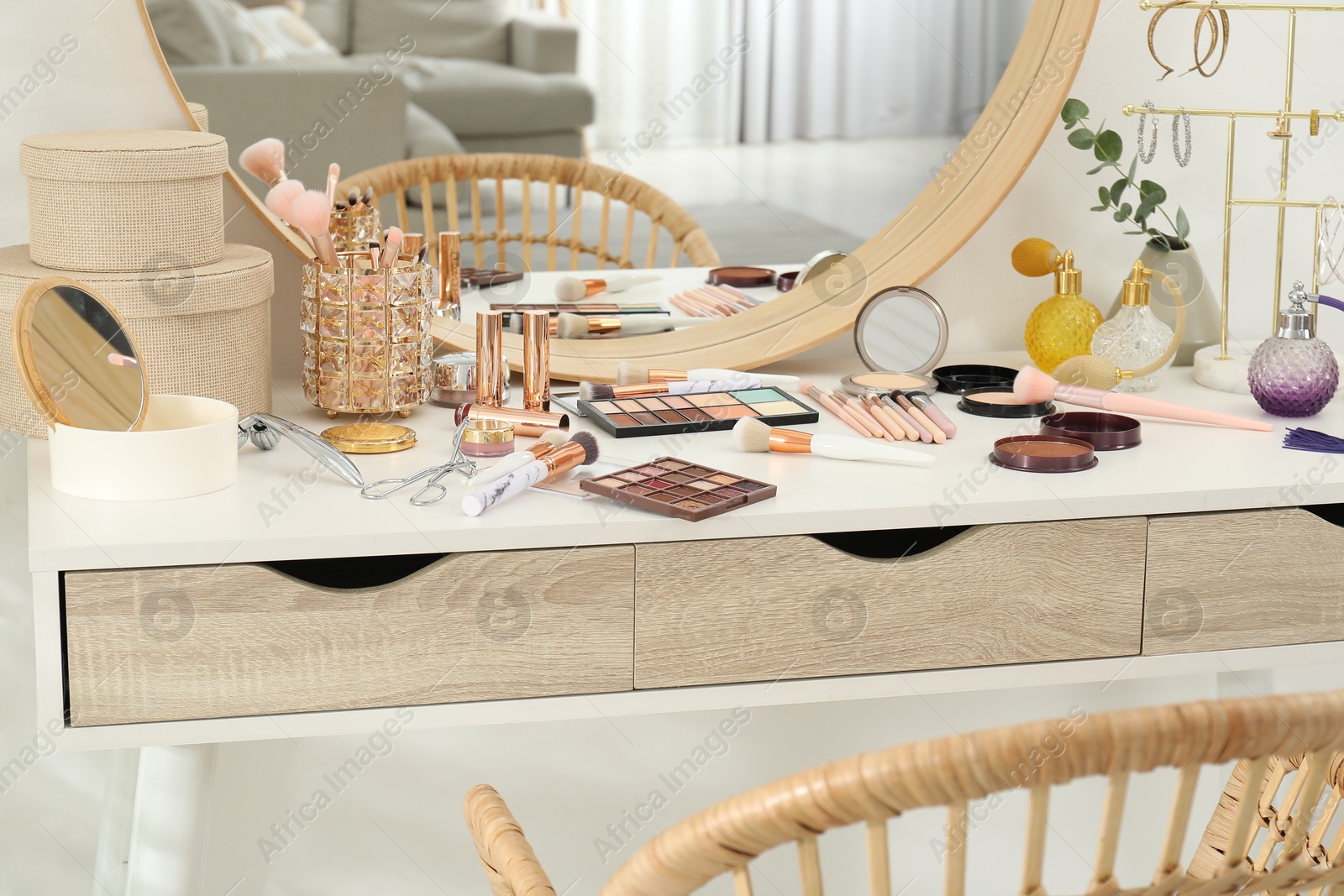 Photo of Makeup room. Dressing table with mirror, different beauty products and chair indoors