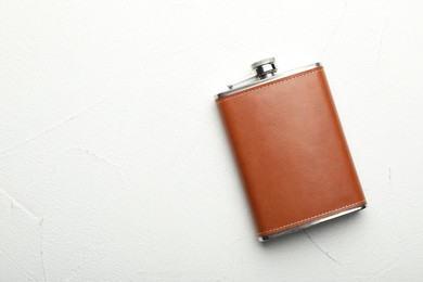 Photo of One hip flask on white table, top view. Space for text