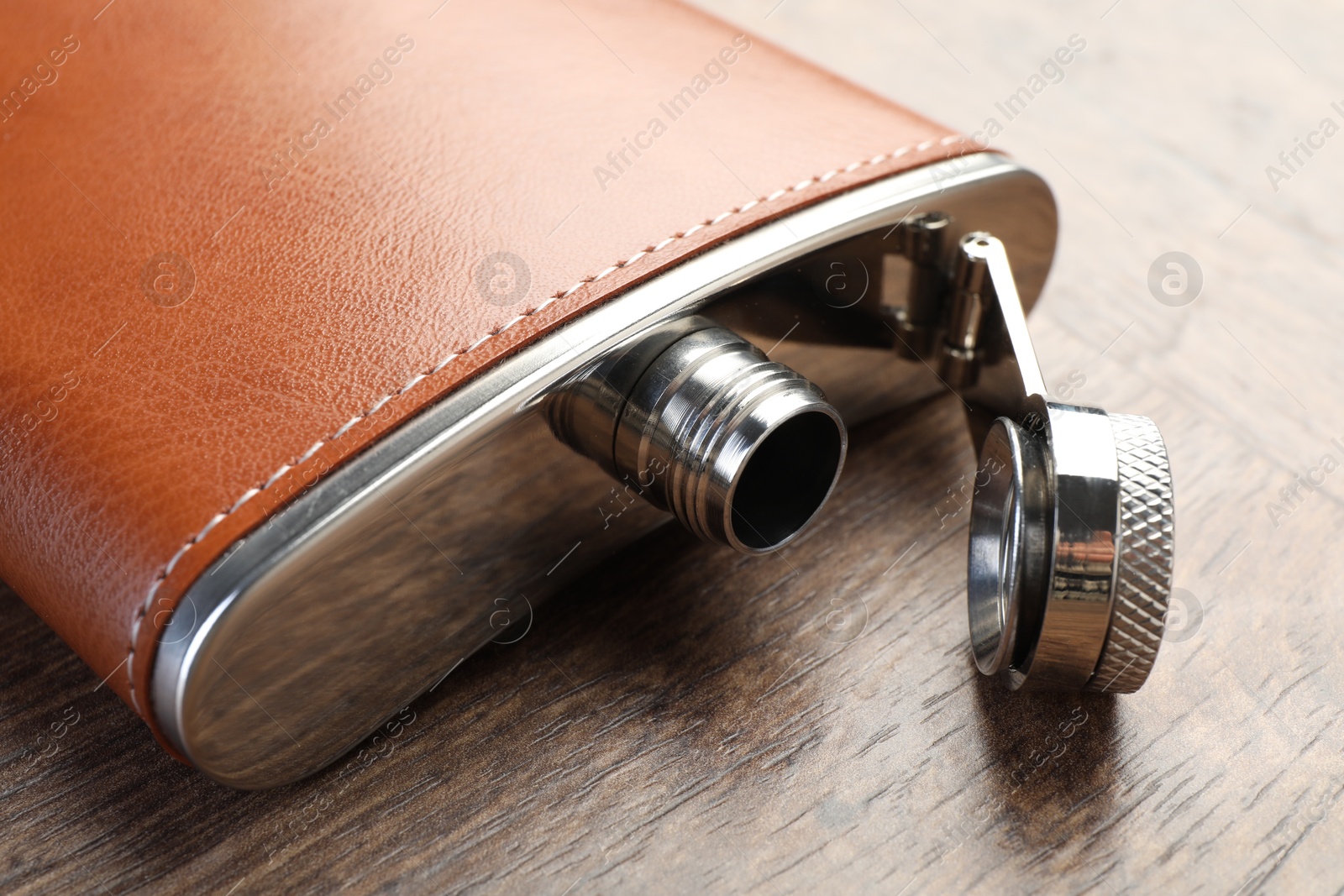 Photo of One hip flask on wooden table, closeup