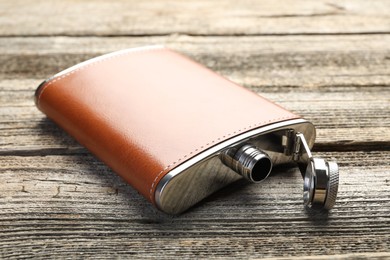 Photo of One hip flask on wooden table, closeup