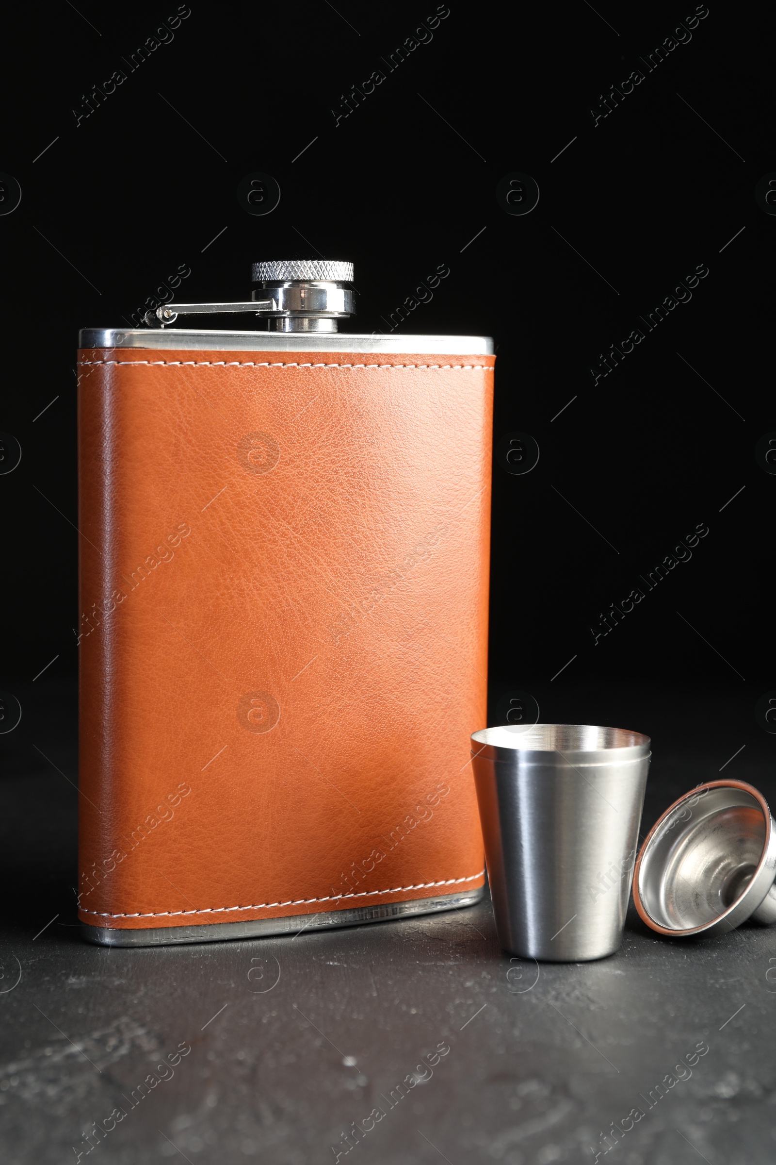 Photo of Hip flask, cup and funnel on black table