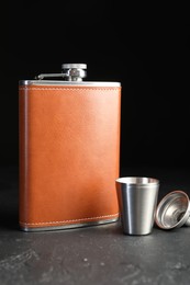 Photo of Hip flask, cup and funnel on black table