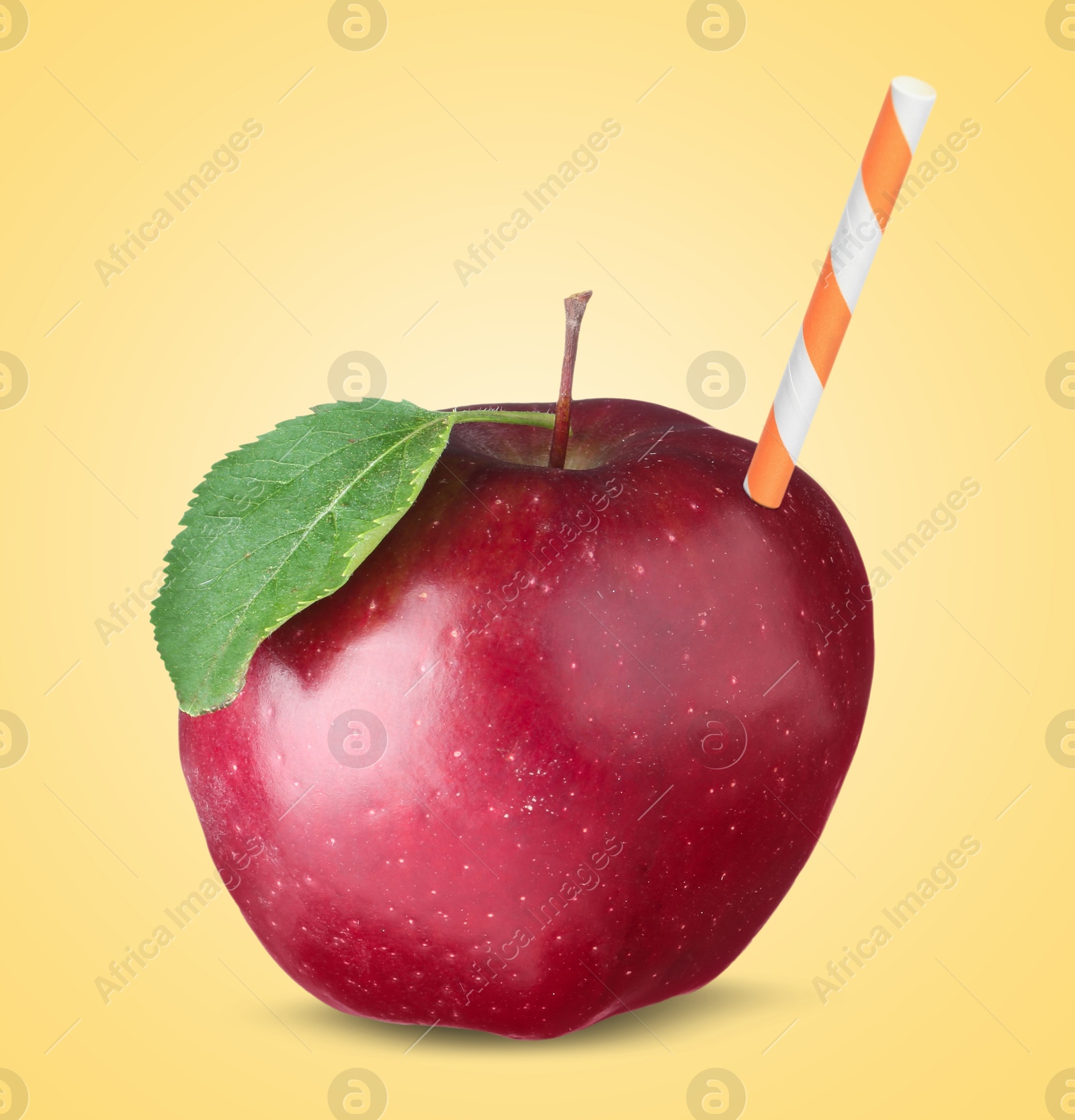 Image of Ripe red apple with drinking straw on yellow background. Organic juice or freshly made smoothie concept