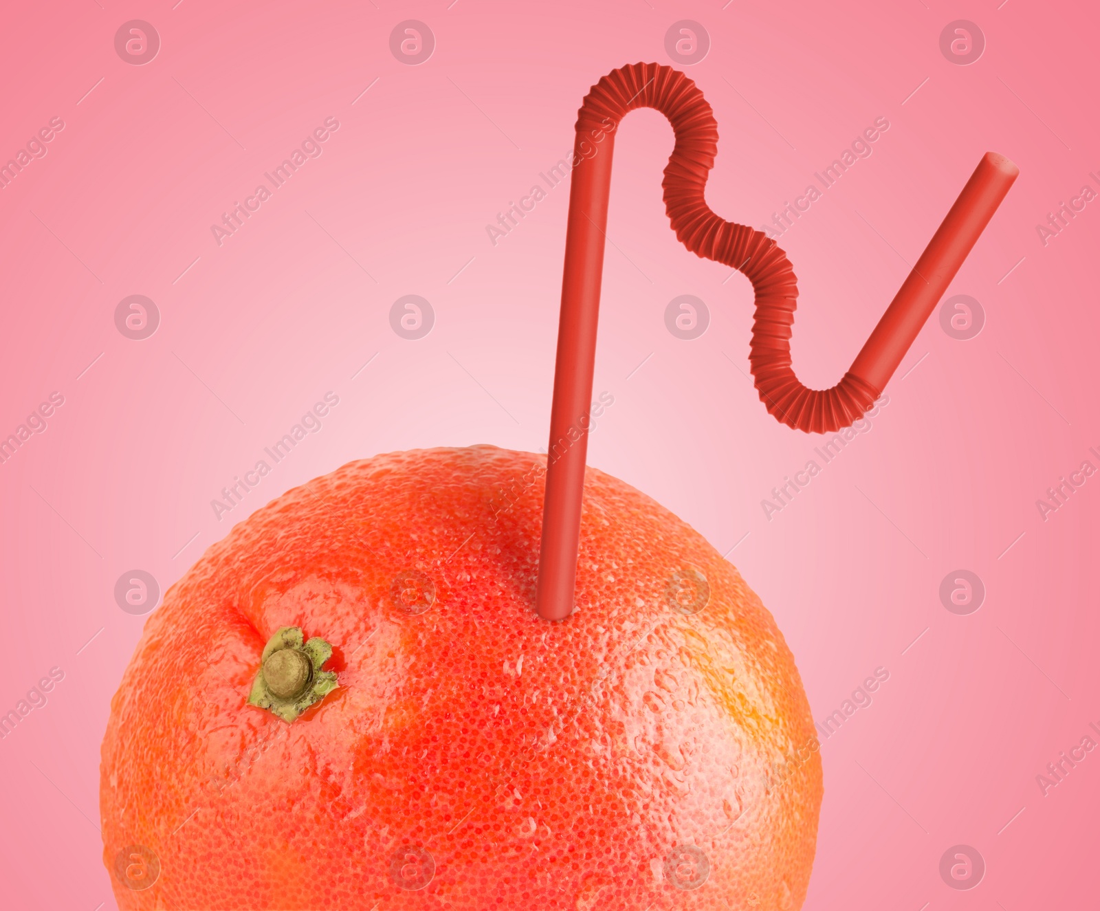 Image of Ripe grapefruit with drinking straw on dark pink background. Organic juice or freshly made smoothie concept