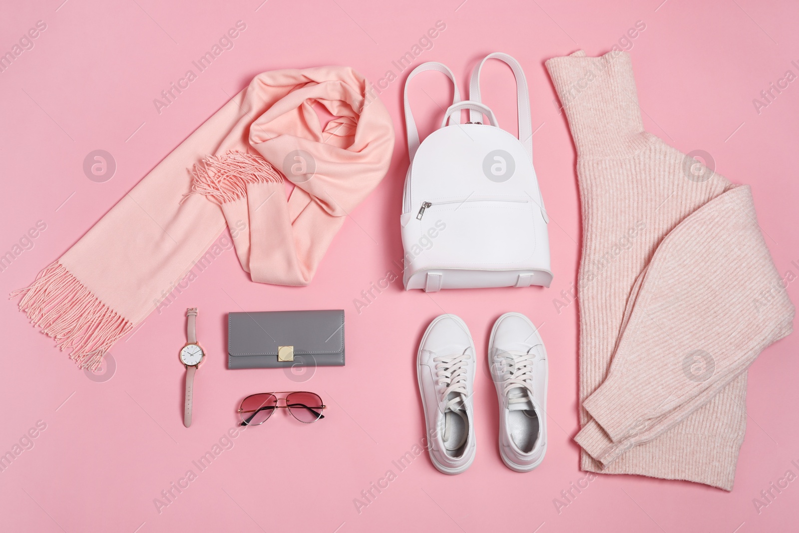 Photo of Stylish outfit with backpack on pink background, flat lay