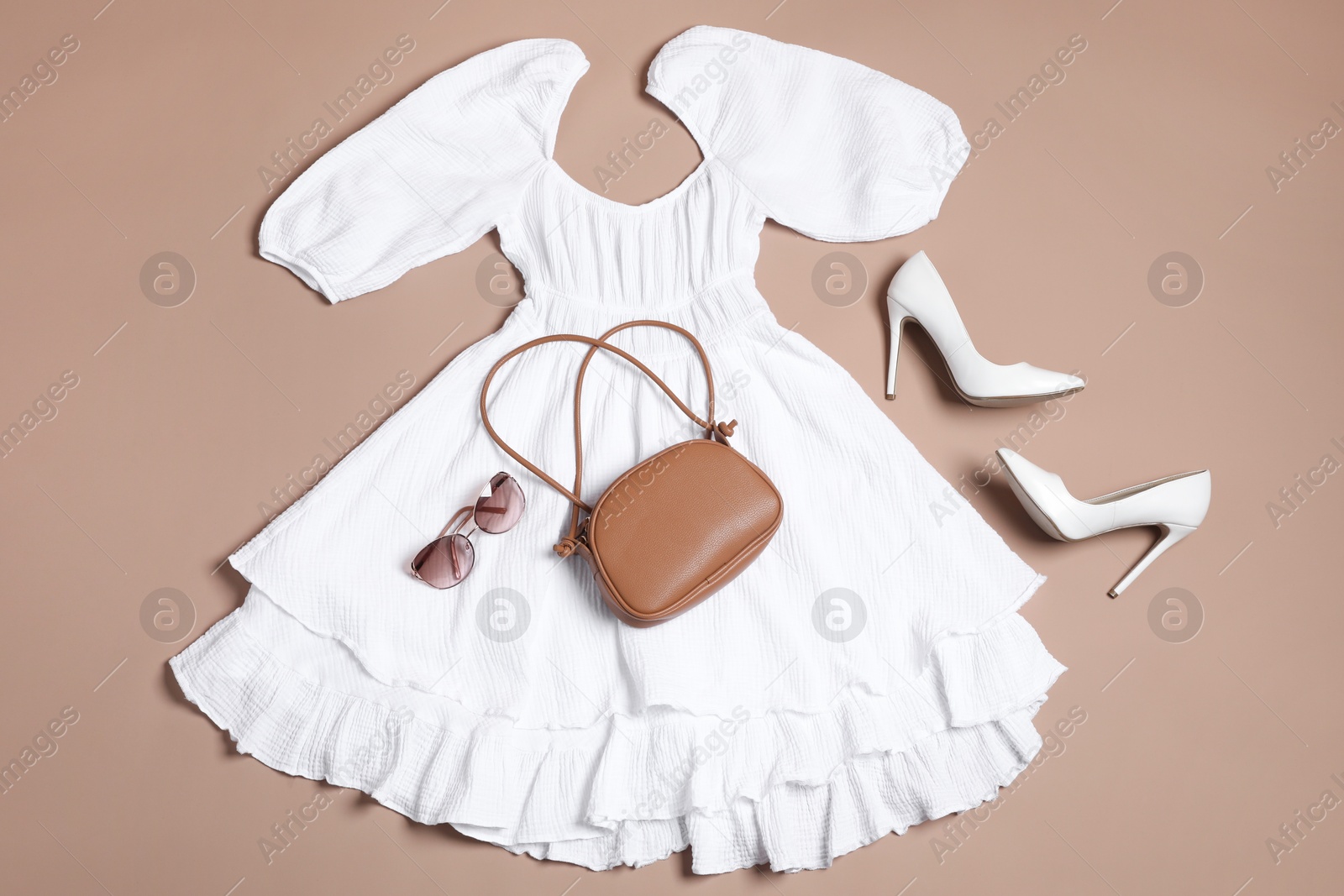 Photo of Stylish outfit with bag on brown background, flat lay