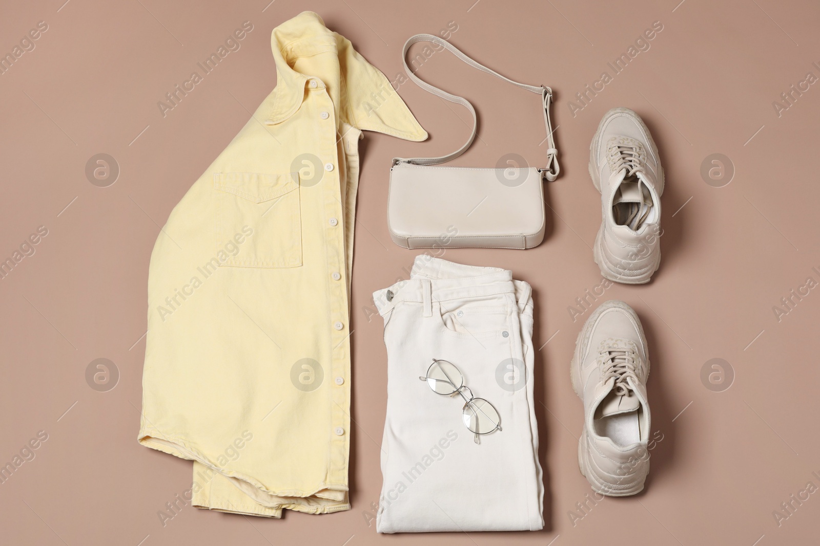 Photo of Stylish outfit with bag on brown background, flat lay