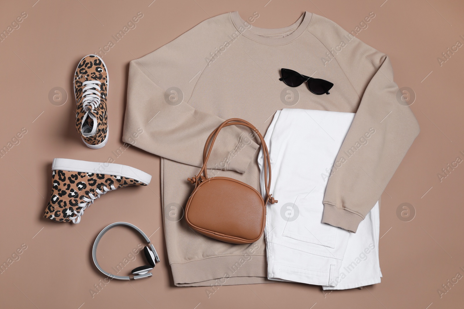 Photo of Stylish outfit with bag on brown background, flat lay