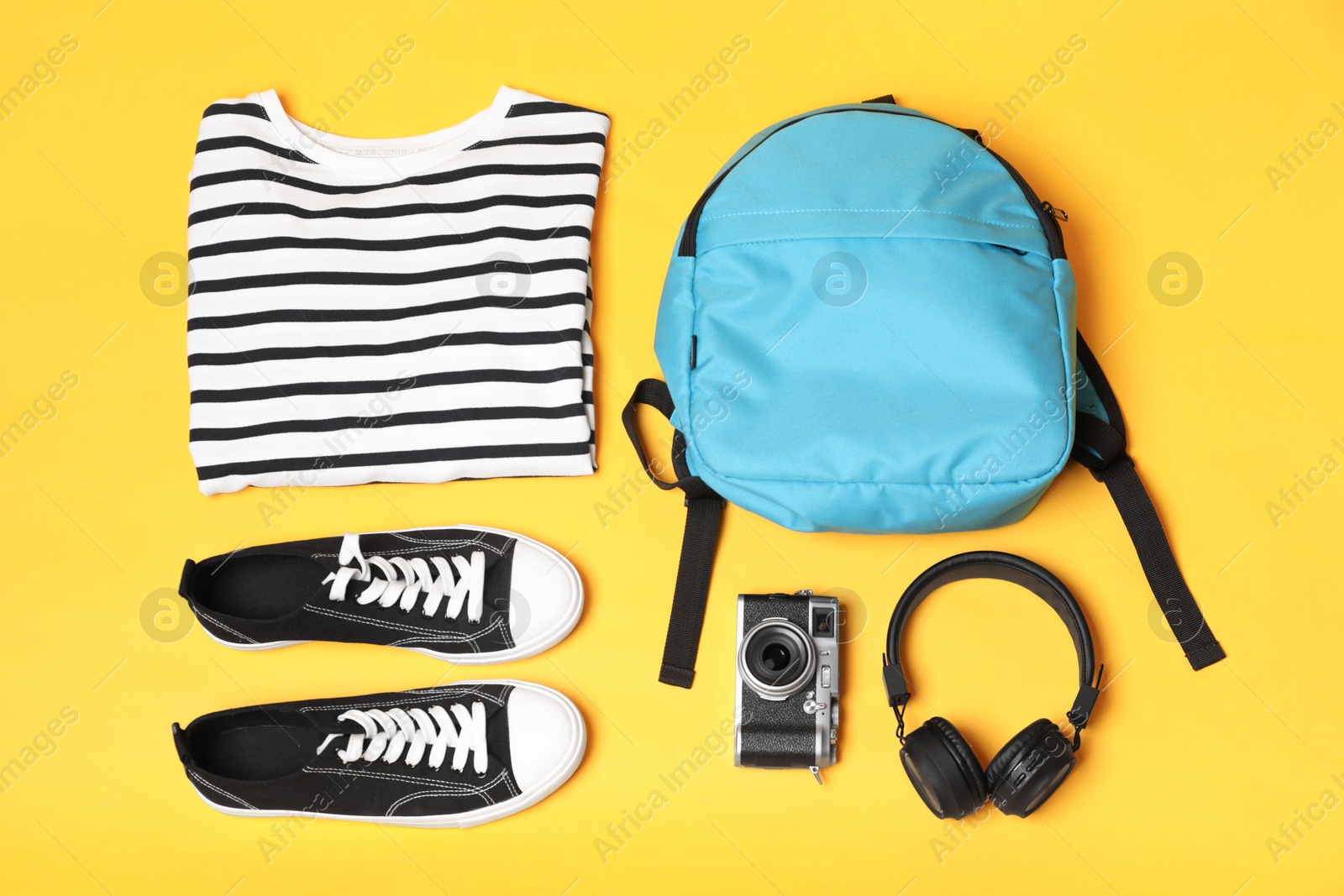 Photo of Stylish outfit with backpack on yellow background, flat lay