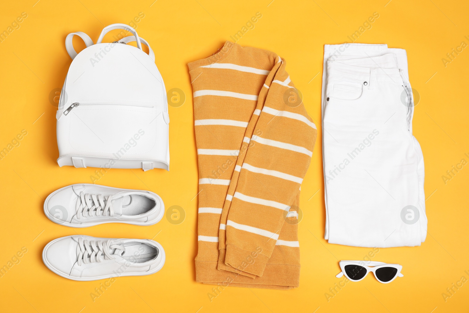 Photo of Stylish outfit with backpack on yellow background, flat lay