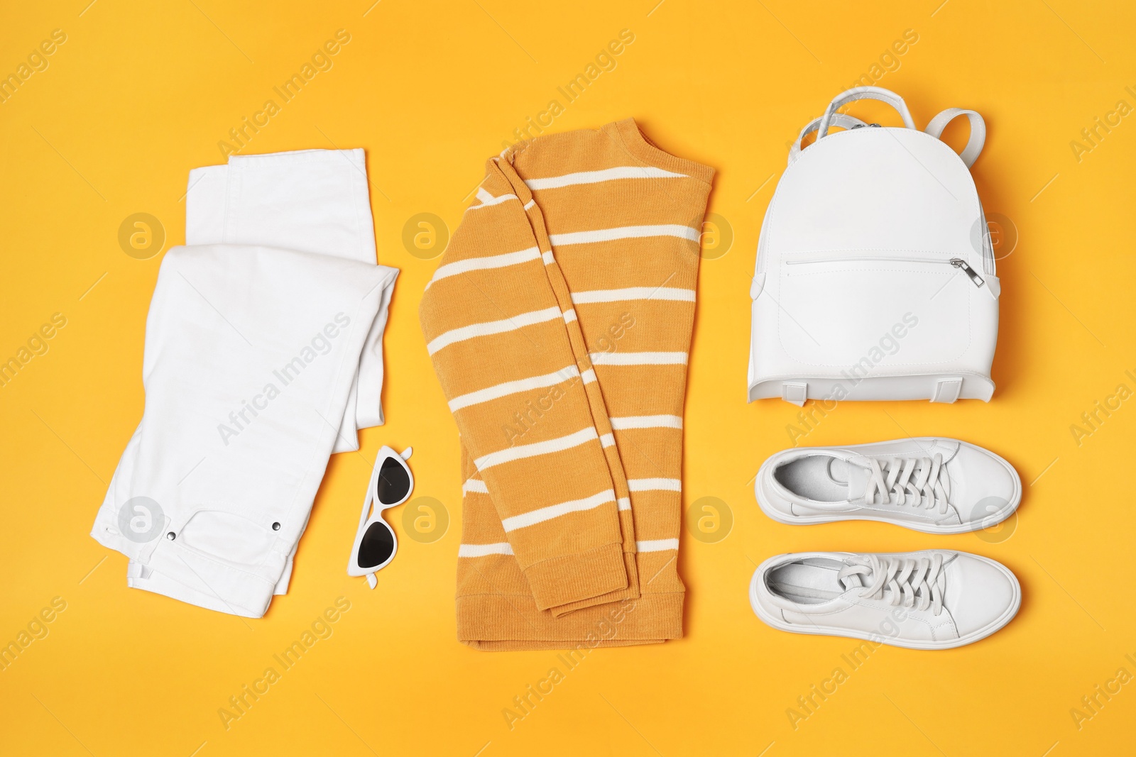 Photo of Stylish outfit with backpack on yellow background, flat lay