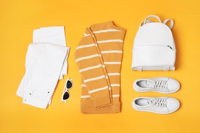 Photo of Stylish outfit with backpack on yellow background, flat lay