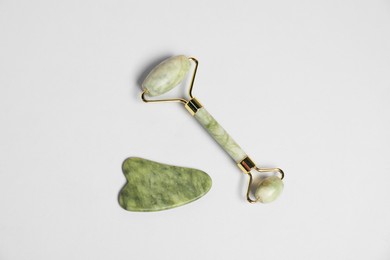 Photo of Face roller and gua sha tool on light background, top view