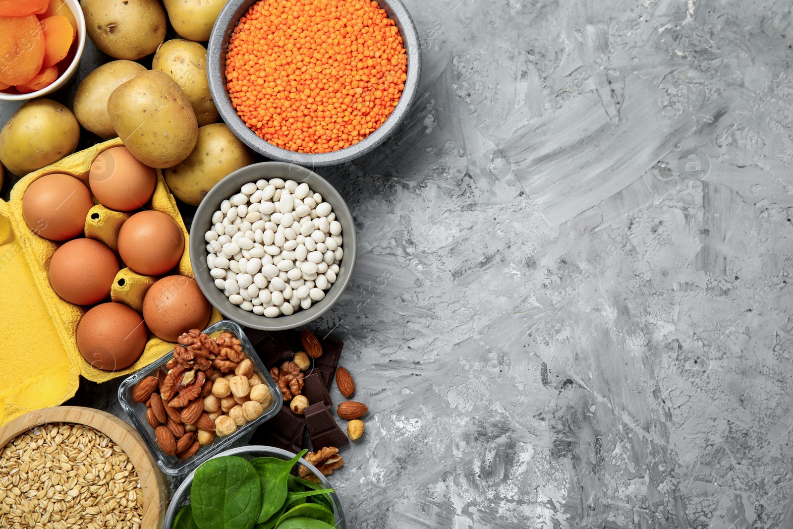 Photo of Diet plan for anemia. Different products rich in iron on grey table, flat lay. Space for text